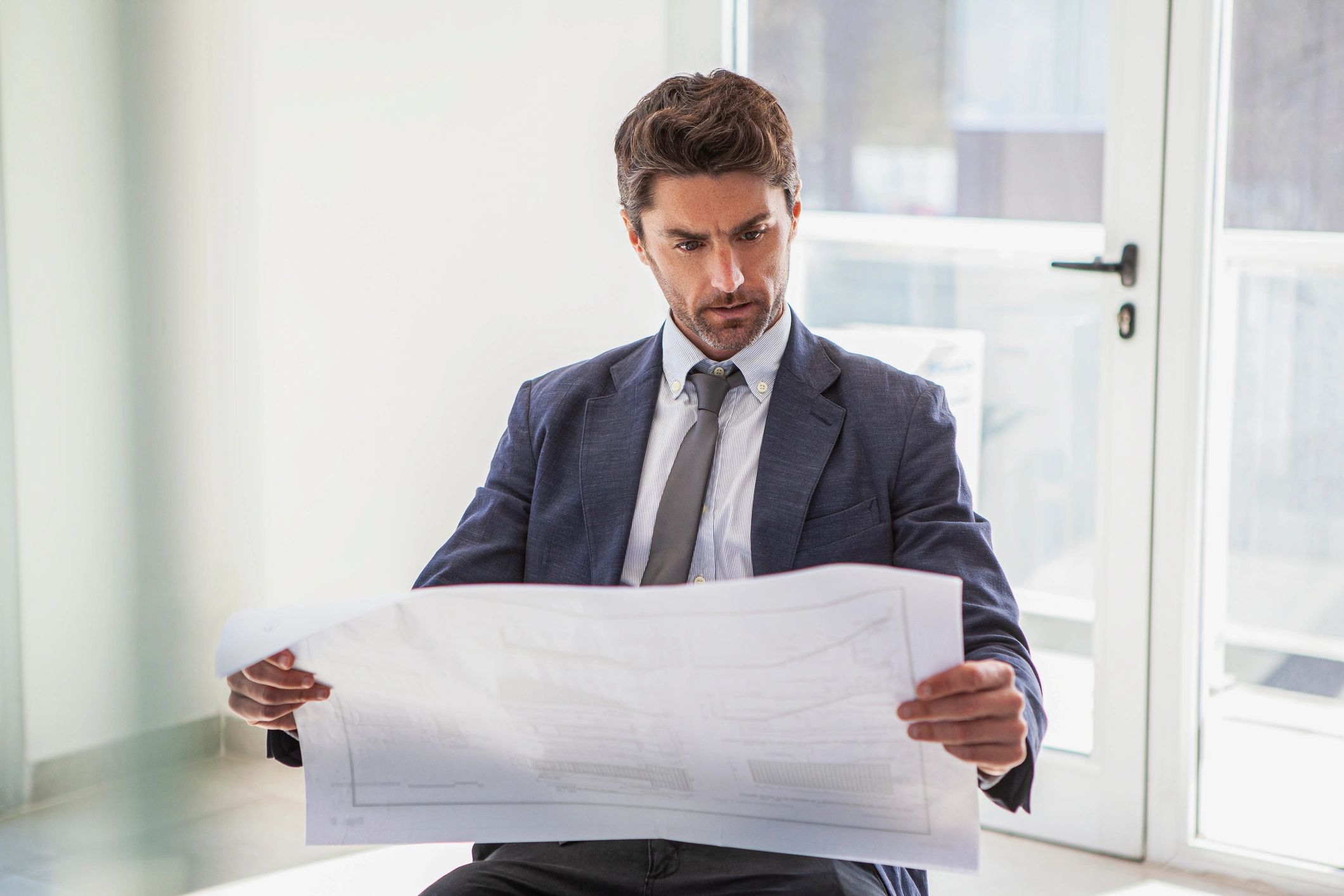 Business professional reviewing blueprints in an office