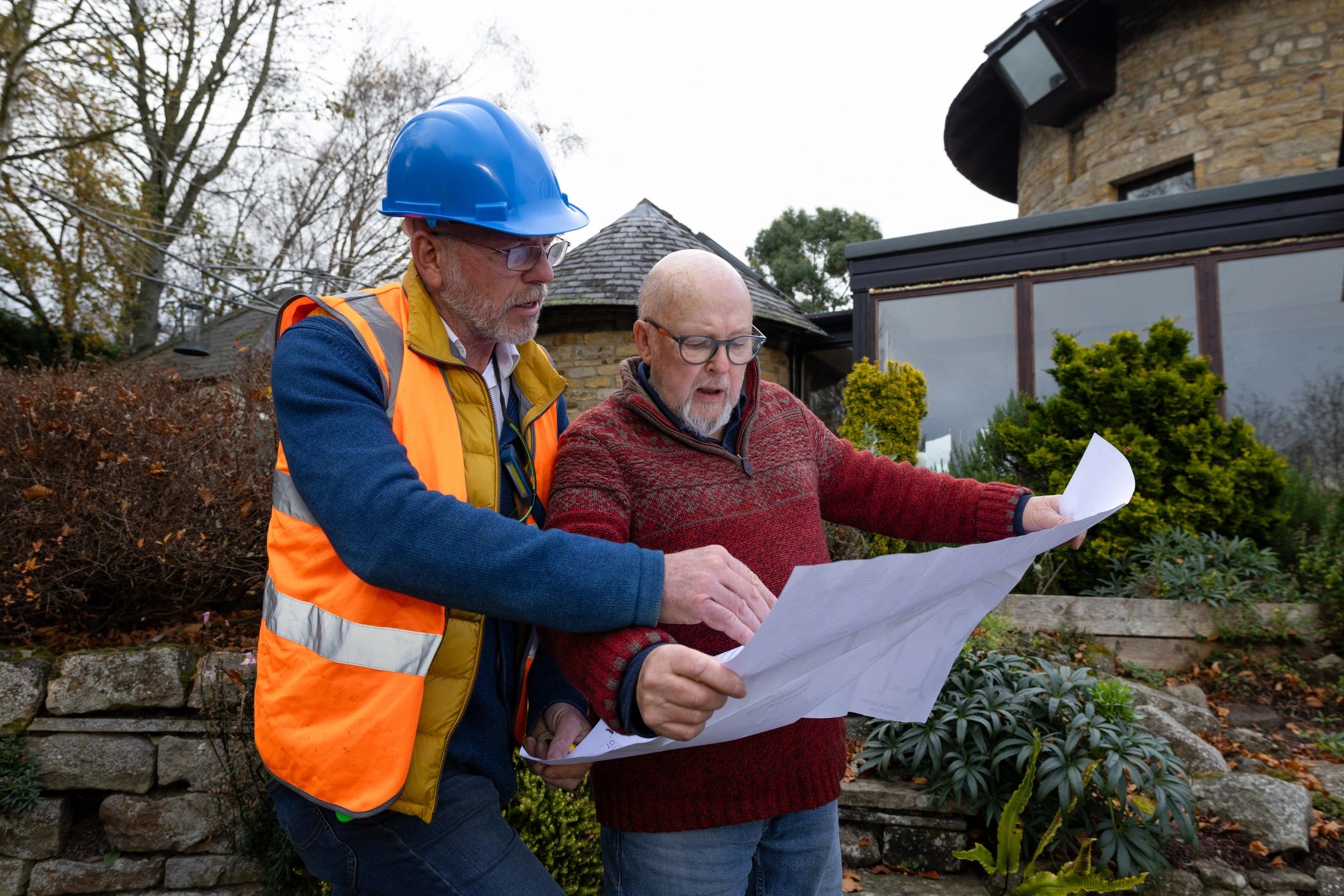 Insurance consultation with contractor reviewing plans